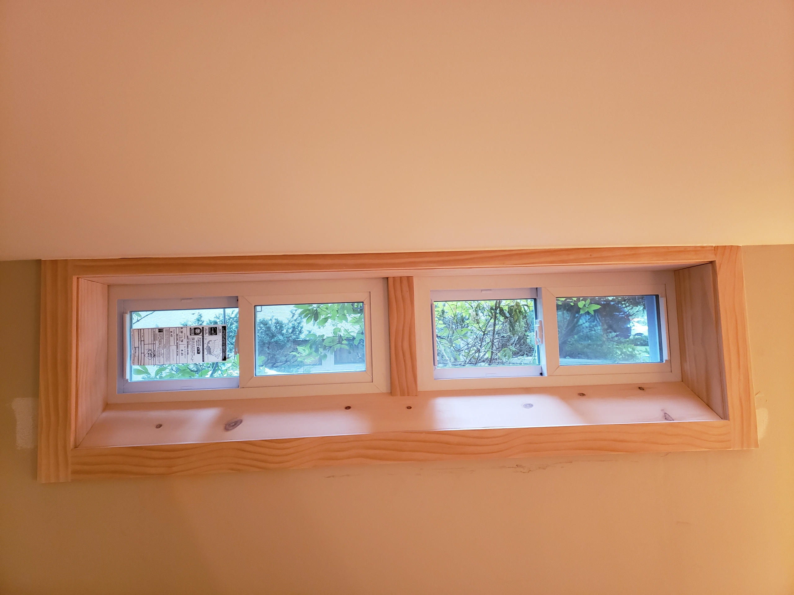 Custom interior pine trim around a wide egress window