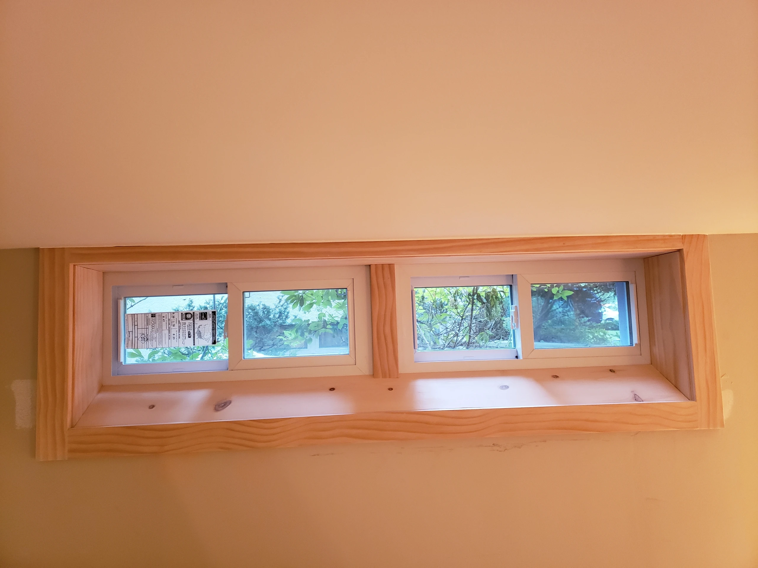 Custom interior pine trim around a wide egress window