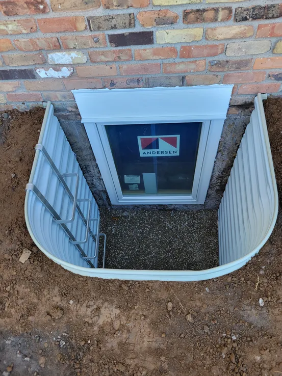 Corrugated metal egress well on brick exterior